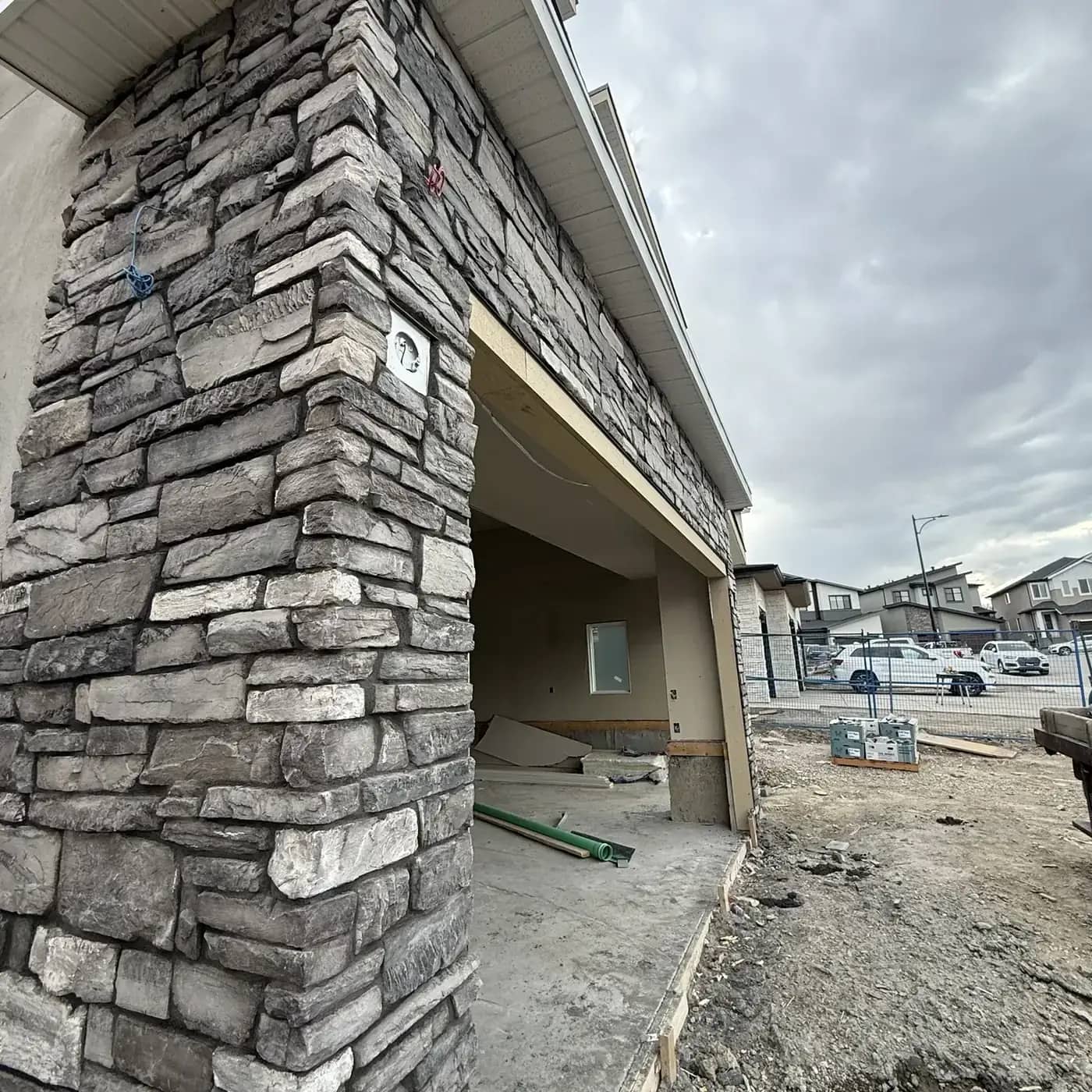 Grey stone column base detail at a concrete foundation and slab edge